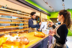A woman is seen checking out in an artisan bakery, representing the need for consistent and high-speed connectivity in modern retail environments. POYNTING’s solutions help ensure reliable communication for seamless point-of-sale operations and customer experiences. Images are used for visual representation purposes only. These images may not be downloaded, copied, or used in any form without prior permission.